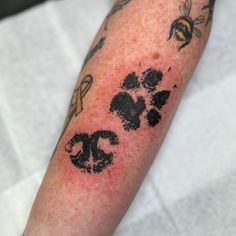 a person with a tattoo on their arm has a dog paw and honeybees