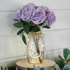 purple roses in a mason jar with fairy lights