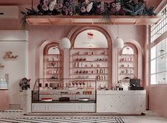 the interior of a pastry shop with pink walls and floral decorations on the windowsill