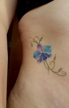 a small blue flower on the side of a woman's stomach