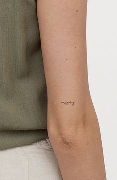 a woman's arm with a small tattoo on the left side of her arm