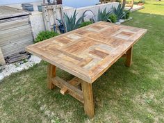 a wooden table sitting on top of a lush green field