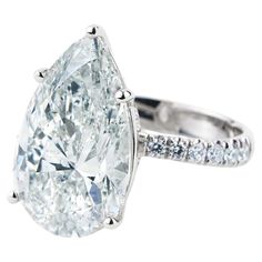 a pear shaped diamond ring with pave set shoulders