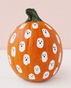 a pumpkin decorated with ghost heads and eyes