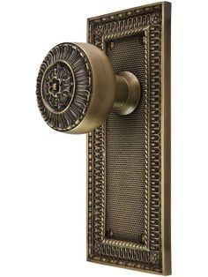 an antique brass door handle with intricate designs on it's side and a decorative knob