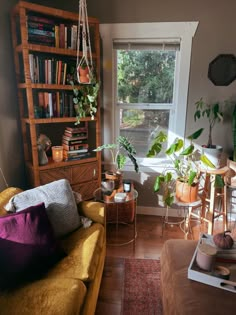 a living room filled with furniture and lots of plants on the windowsill, next to a window sill