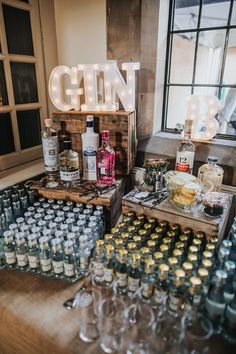 bottles and glasses are on display in front of a sign that reads gin bar with the word gin above them