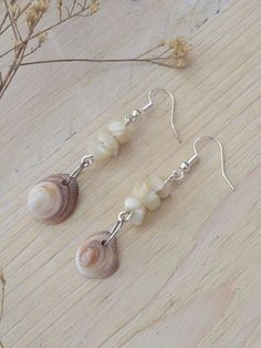 A super fun set of drop earrings made with natural shell chip beads. A one of a kind look.  Turning a natural treasure into a piece of wearable art is almost as healing as the time spent to collect the piece.  This set of earrings was made from a variety of small size and design shell chip beads accented with a tiny genuine sea shell hanging as a statement piece.  Your jewelry will arrive ready for gift-giving in a natural designed gift box.  Don't forget to mark the gift option to add a special message to that special someone when sending as a gift.  Natural shell is commonly believed to attract prosperity and is often used in mystical work and lore to heighten intuition, psychic sensitivity and imagination. It is believed that mother-of-pearl shell offers soothing, motherly protection fr Carved Shell Jewelry, Hawaiian Shell Jewelry, Shell Earrings Diy Seashell Jewelry, She’ll Earrings, Shell Earrings Diy, Diy Shell Jewelry, Shell Jewelry Ideas, Diy Seashell Jewelry, Sea Shell Hanging