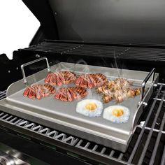 an open grill with eggs and meat cooking on it