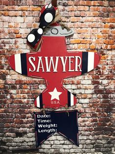 a sign that is on the side of a brick wall saying, sawyer with an airplane