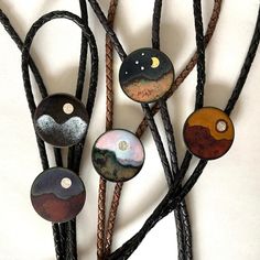 "These are all bolos I offer individually, and have a few in stock. I set this up for larger made-to-order sales. In the order shown, they are desert moon, desert sun, Mars sunset, moon eclipse and moon mountain. These are all made by enameling copper, that is, kiln-firing glass onto a copper base at 1350˚-1600˚F. The suns are fine silver under a layer of clear enamel. These are handcrafted and high quality. No two will be identical. The string tie is a choice of: woven black rayon cord black br Handmade Elegant Bolo Ties For Gift, Handmade Elegant Bolo Ties As A Gift, Artisan Adjustable Jewelry For Wedding, Artisan Adjustable Wedding Jewelry, Artisan Jewelry With Adjustable Length For Gift, Artisan Jewelry With Adjustable Length As Gift, Handmade Gold Bolo Tie For Gift, Unique Handmade Adjustable Bolo Ties, Handmade Unique Bolo Ties