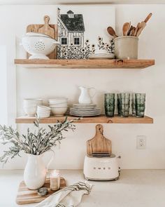 the shelves are filled with dishes and kitchen utensils, such as cutting boards