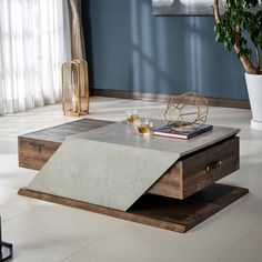 a coffee table with two glasses on it and a plant in the corner next to it