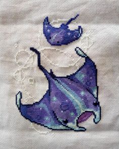 a cross stitched picture of a purple fish