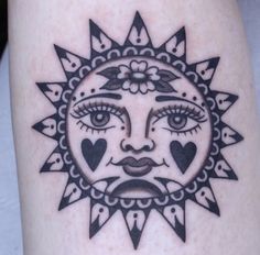 a sun tattoo on the leg of a woman's legs, with hearts in her eyes