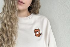 Add a touch of wild charm to your wardrobe with our Tiger Embroidered Crewneck Sweatshirt. Made from a soft cotton blend, this relaxed fit pullover features a striking tiger embroidery, capturing the essence of bold and unique style. The unisex design makes it perfect for everyone, offering a stylish and comfortable option for any casual occasion. Whether you're lounging at home or heading out, this sweatshirt brings warmth and wild flair to your look. Cute Cotton Sweatshirt For Everyday, Cute Cotton Everyday Sweatshirt, Cute Everyday Cotton Sweatshirt, Lover Style, Tiger Embroidery, Embroidered Crewneck, Embroidered Sweatshirt, Embroidered Sweatshirts, Unisex Design