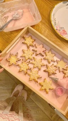 someone is decorating some cookies with icing on the table in front of them