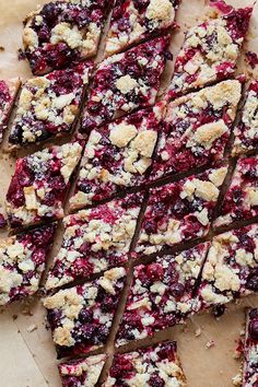 berry crumble bars cut into squares on top of a cutting board with one slice missing