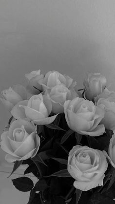 a vase filled with white roses on top of a table