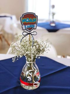 a vase filled with baby's breath sitting on top of a blue table cloth