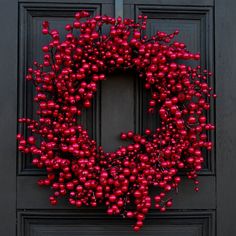 a red berry wreath on a black door