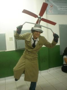 a man in trench coat and top hat holding up a fan over his head while standing on tiled floor