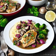 a white plate topped with chicken, mushrooms and broccoli