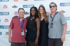 three women and one man are posing for a photo on the red carpet at an event