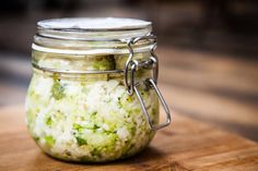 a glass jar filled with food sitting on top of a wooden table