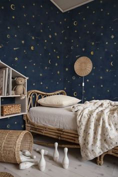 a bedroom decorated in blue and white with stars on the wall, wicker bed frame