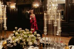 a man and woman standing next to each other in front of a dining room table