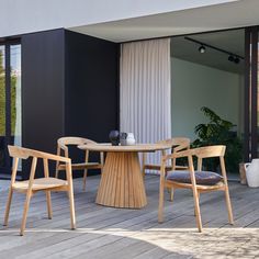 three chairs and a table on a wooden deck