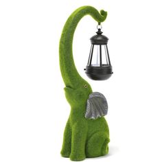 an elephant statue with a lantern on its back and a lamp hanging from it's trunk