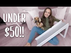 a woman sitting on the floor with her dog and under $ 50 sign in front of her