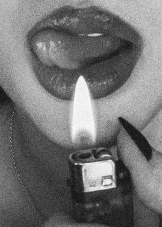 a woman holding a lighter in her mouth with the light on it's side