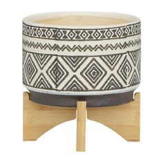 a black and white planter sitting on top of a wooden stand