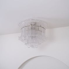 a chandelier hanging from the ceiling in a room with white walls and ceilings