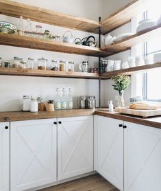 a kitchen with white cabinets and open shelves