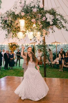 a bride and groom dancing on the dance floor at their wedding reception in a tent