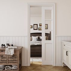 an open door leading to a bedroom with white walls and wood flooring on the other side