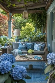 a blue couch sitting on top of a wooden table next to a lush green forest