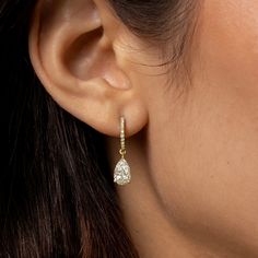 Simply elegant, and absolutely gorgeous. Welcome these timeless diamond dangle earrings into your life! We make our pear cut diamond drop, diamond huggie hoop earrings in your choice of 18k gold (rose, yellow, or black, or white). Here, in 18k yellow gold. 18k yellow gold pear cut diamond drop earring on diamond-faced hinged huggie hoops. 2.12cts (pair) of white diamonds. F color, VS1 clarity 18k yellow gold hardware. Diamond-faced hinged huggie hoop earwires with hidden closure. Lovingly, skill Luxury Yellow Gold Huggie Earrings For Wedding, Luxury Classic Huggie Earrings For Wedding, Timeless Luxury Huggie Diamond Earrings, Luxury Halo Huggie Earrings For Wedding, Luxury Pear-shaped Hoop Earrings For Formal Occasions, Luxury Dangle Huggie Earrings, Luxury Huggie Dangle Earrings, Luxury Yellow Gold Hinged Huggie Earrings, Fine Jewelry Teardrop Huggie Earrings With Diamond Accents