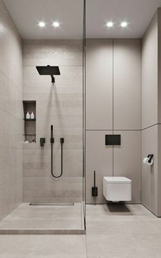 a bathroom with a walk in shower next to a white toilet and black faucet