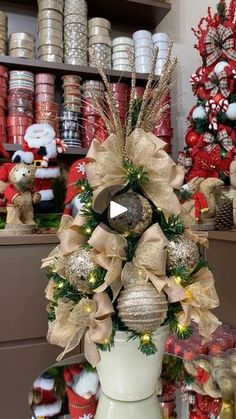 a christmas tree with gold and silver ornaments in a room filled with other holiday decorations