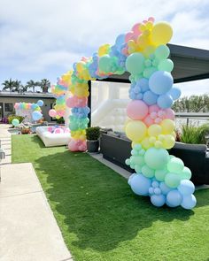 an arch made out of balloons on the grass