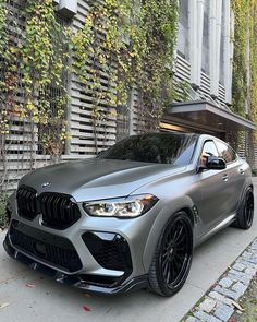 a silver bmw suv parked in front of a building