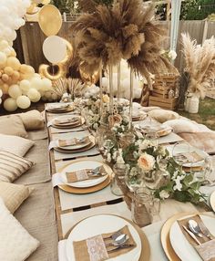 a table set with plates, silverware and gold napkins for an outdoor party