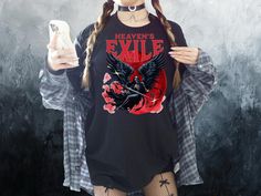 Introducing our Grunge Horror Tee, perfect for those who love to embrace their dark side. This Fallen Angel Retro T-Shirt features a unique Heaven & Hell themed design, making it a standout piece in any wardrobe. Whether you're into alternative, punk, or goth styles, this top is sure to make a statement. It's the ideal gift for those who appreciate dark and edgy fashion, and it's also a great choice for witches who have a love for all things dark cottagegore. Add a touch of darkness to your outf Emo Graphic Print T-shirt For Cosplay, Emo Cosplay T-shirt With Crew Neck, Edgy Graphic Print Top For Cosplay, Edgy Crew Neck Top For Cosplay, Alternative Style Cosplay Tops With Crew Neck, Emo Short Sleeve Tops For Cosplay, Alternative Crew Neck Top For Cosplay, Short Sleeve Emo Tops For Cosplay, Edgy Halloween Cosplay T-shirt