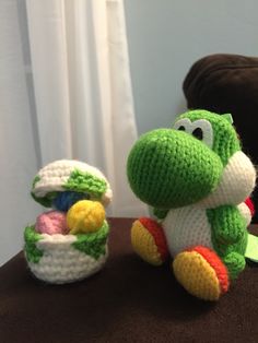 a crocheted toy sitting on top of a table next to a stuffed animal