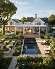 a large white house with a pool in the middle and lots of greenery around it